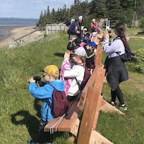 Les jeunes sont face à la mer et regardent au long dans des jumelles.