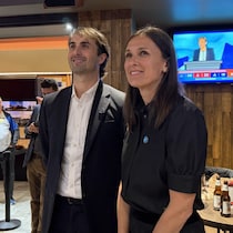 Un homme et une femme souriants regardent un écran dans un restaurant