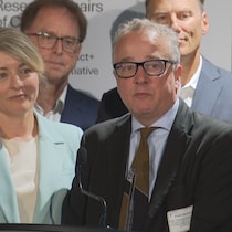 Mélanie Joly à gauche, en retrait, aux côtés de Peter Caravan au lutrin.