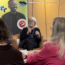 Chrystine Brouillet parle au micro devant un public.