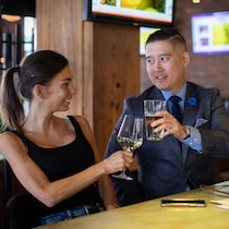 Un homme et une femme trinquent avec des verres d'alcool.