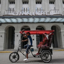Un homme transporte une femme dans un tuk-tuk.