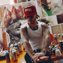 David Brown devant des peintures.
