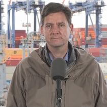 David Eby. Derrière lui, une centaine de conteneurs.