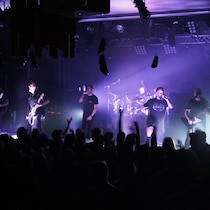 Six hommes font de la musique sur une scène.