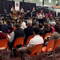 Des centaines de personnes assises sur des chaises assistent à la remise des diplômes des étudiants de l'Université de l’Île-du-Prince-Édouard.