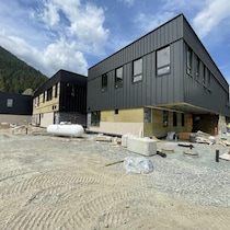 Une école en construction avec des montagnes en arrière-plan.