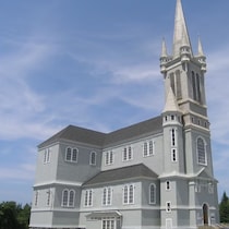 Une photo de l'église grise prise en été.