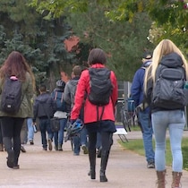 Des étudiants portant des sacs à dos marchent sur le campus de l'Université de Calgary.