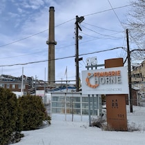 L'affiche de la Fonderie Horne et l'une des cheminées de l'usine.