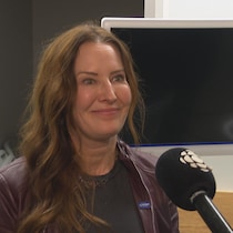 Une femme sourit en mêlée de presse.