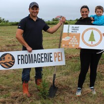 Une famille tient deux affiches dans un champ.