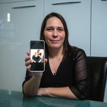 Geneviève Coutu tient un téléphone qui montre une photo d'elle avec son mari.