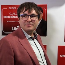 Guillaume Deschênes-Thériault devant des affiches du parti libéral.