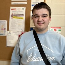 Un jeune homme regarde directement la caméra pour une photo.