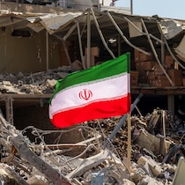 Un drapeau iranien est placé au milieu des décombres et des débris à côté d'un immeuble résidentiel détruit près de la place Ferdowsi à Téhéran.