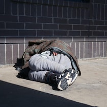Une personne sans-abri couchée sur un trottoir de Saskatoon, en Saskatchewan, le 9 avril 2026.