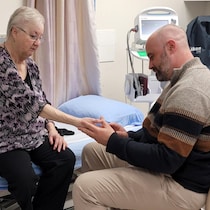 Le médecin examine la main d'une patiente dans un cabinet de consultation.