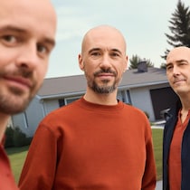 Trois hommes posent.