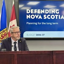 John Lohr est assis à un bureau devant des drapeaux.
