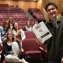 Justin Chénier avec quelques élèves de Timmins dans une salle de spectacle.