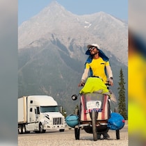 Kristians Karklins pousse un chariot devant une montagne, au coeur des rocheuses.