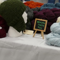 Plusieurs pelotes de laine allant du bleu au violet au blanc.  