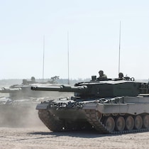 Deux chars d'assaut dans la poussière, lors d'un entraînement sur une base militaire.