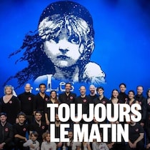 Les comédiens et comédiennes posent sur scène devant l'affiche de la comédie musicale. 