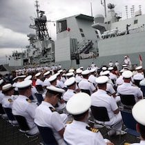Le NCSM Calgary est visible derrière des marins lors d'une cérémonie de passation de commandement à la BFC Esquimalt, en Colombie-Britannique, le mercredi 24 juin 2015.