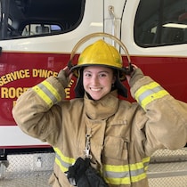 Portrait de Makayla Gaudet devant un camion de pompier.