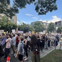 Des manifestants tiennent des pancartes.