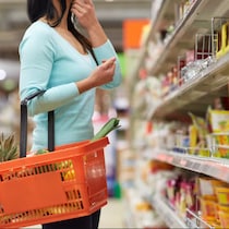 Une personne tenant un panier dans une épicerie