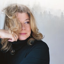Portrait de Marina Orsini devant des sapins dans la brume.