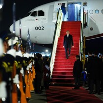 Mark Carney descend d'un avion et est accueilli en grandes pompes.