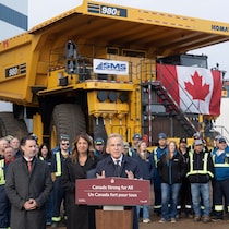 Mark Carney et Danielle Smith sont devant un immense camion lors d'une conférence de presse.