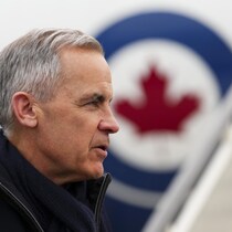 Mark Carney devant son avion officiel.