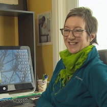 Souriante, Maud Beaulieu est assise devant son ordinateur.