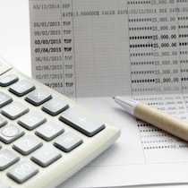 Un carnet de banque, un stylo et une calculatrice