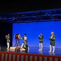 Des artistes vêtus d'habits traditionnels interprètent une pièce musicale à la flûte et aux tambours taiko sur scène lors du festival Matsuri à Regina.