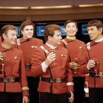 Sept personnages de Star Trek célèbrent un verre à la main.