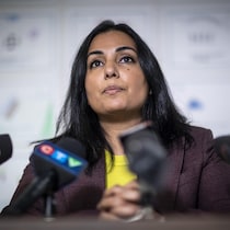 Niki Sharma parle devant des micros.