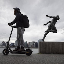 Une personne sur une trottinette électrique dans Vancouver.