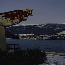Le monument SS Empress of Japan Figurehead sur le bord du Seawall du parc Stanley, pointant vers la mer et les montagnes.