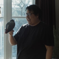 Un homme qui tient un oiseau sourit à une femme.