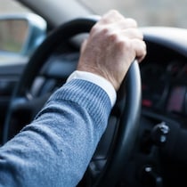 Une personne aînée qui conduit. 