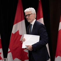 Philippe Dufresne marche avec des documents.