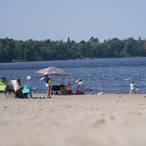Un surveillant et des baigneurs sur une plage.