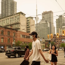 Des passants à l'intersection Queen et Spadina.