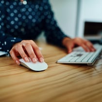 Gros plan d'une femme travaillant sur un ordinateur dans un bureau.
